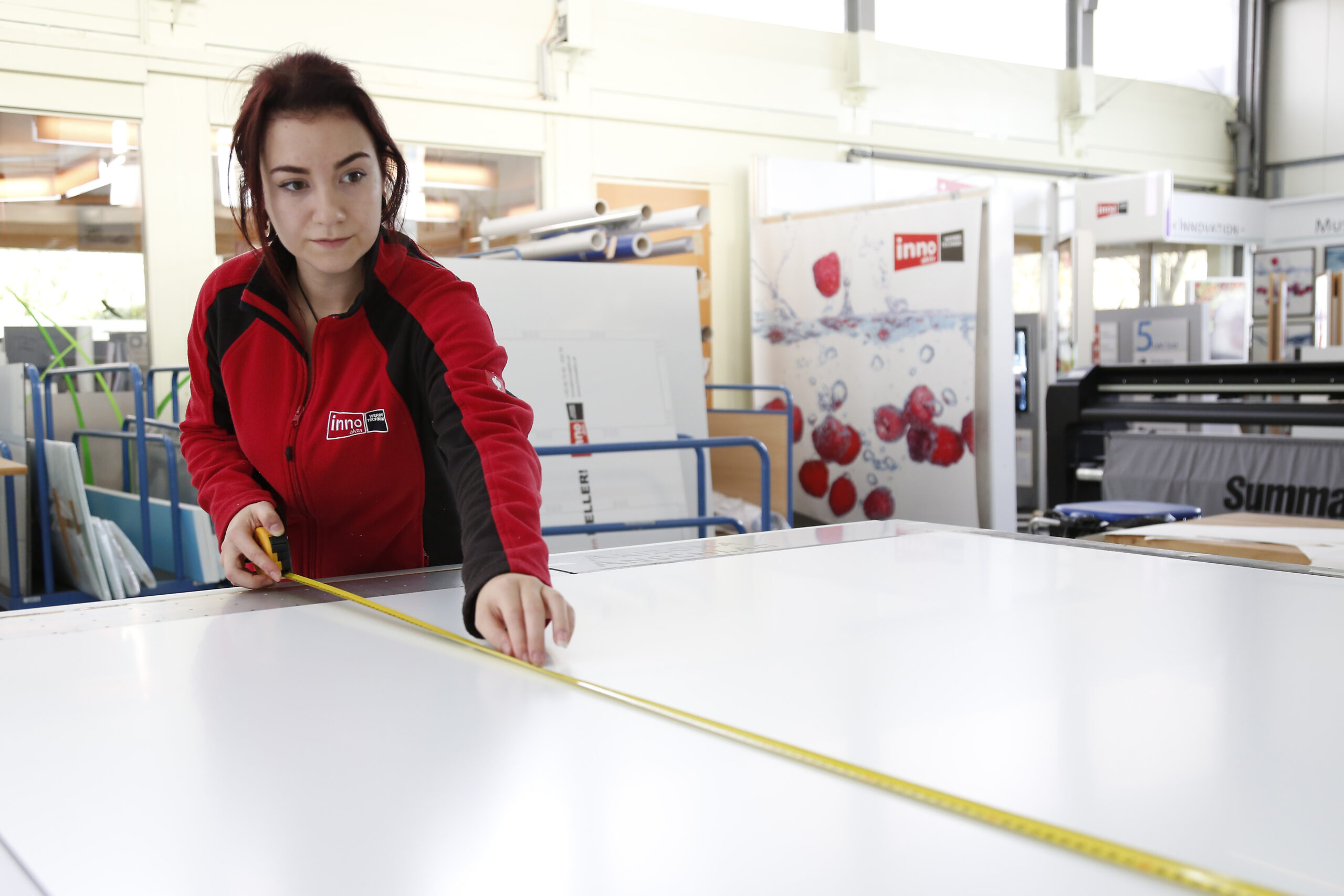 Mitarbeiterin beim Abmessen einer Werbetafel