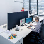 KLemmbare Akustik-Trennwand zwischen zwei Schreibtischen