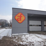 Firmenlogo in Kontur gefräst an Gebäudefassade