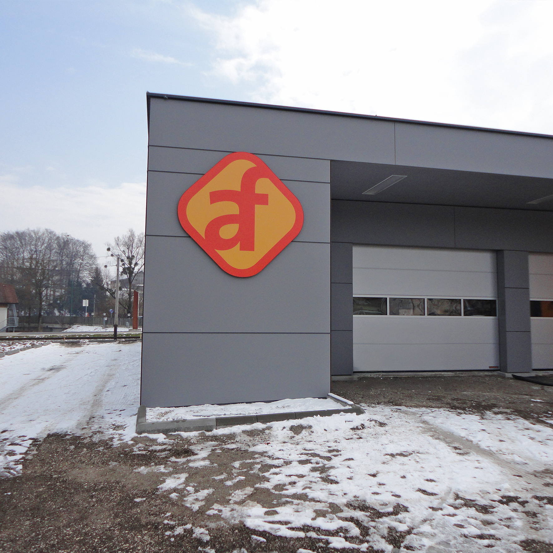 Firmenlogo in Kontur gefräst an Gebäudefassade