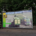 Lichtdurchlässige Fassadenplane aus Mesh-Gewebe mit Werbedruck auf Baugerüst“