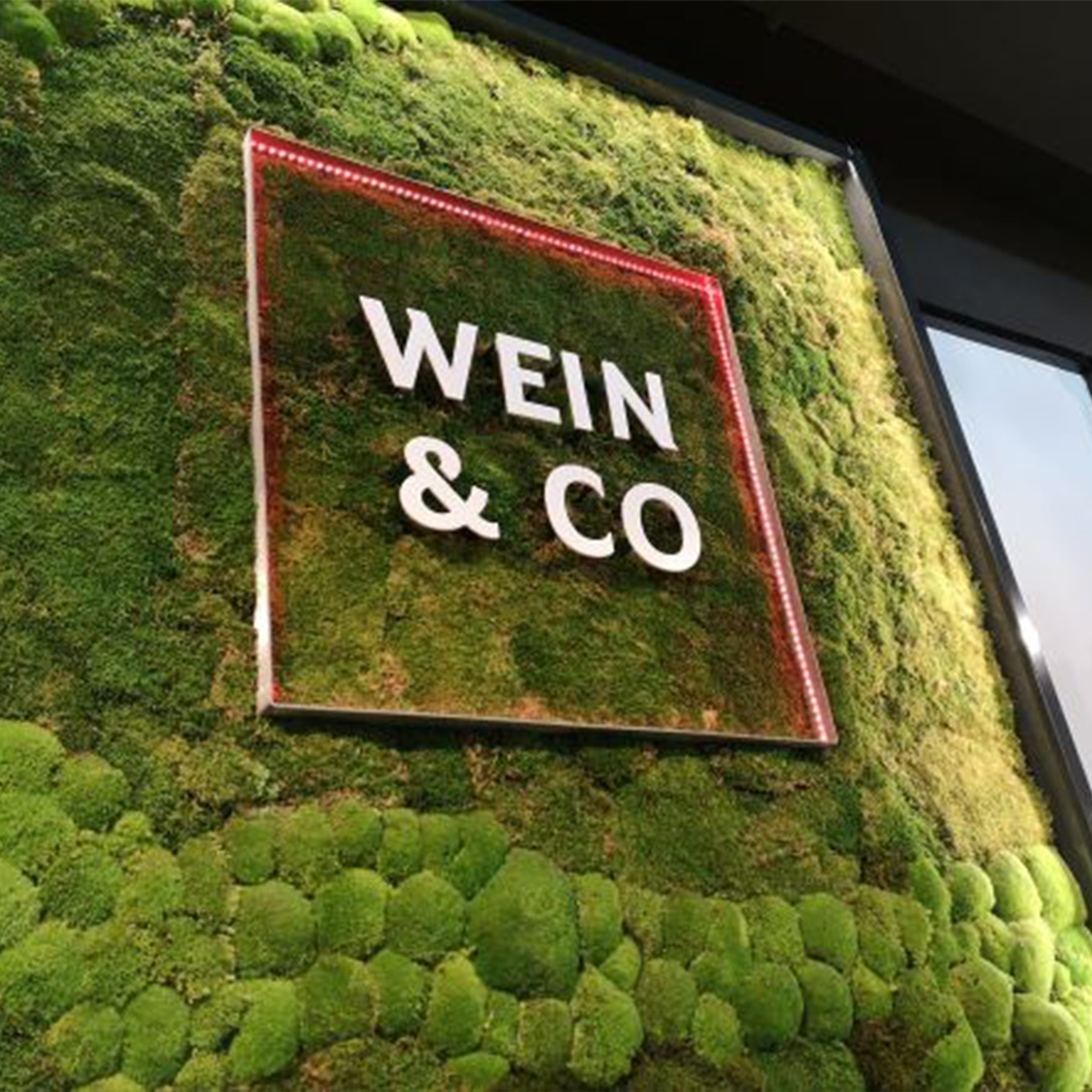 Metallbuchstaben als elegante Wandbeschriftung kombiniert mit einer Mooswandgestaltung