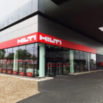 Wetterfeste Spanntuchfront mit konturgeschnittenem Logo auf Fassade