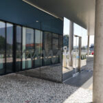 Glasfassade mit Sonnenschutzfolie für UV- und Hitzeschutz kombiniert mit Firmenlogo