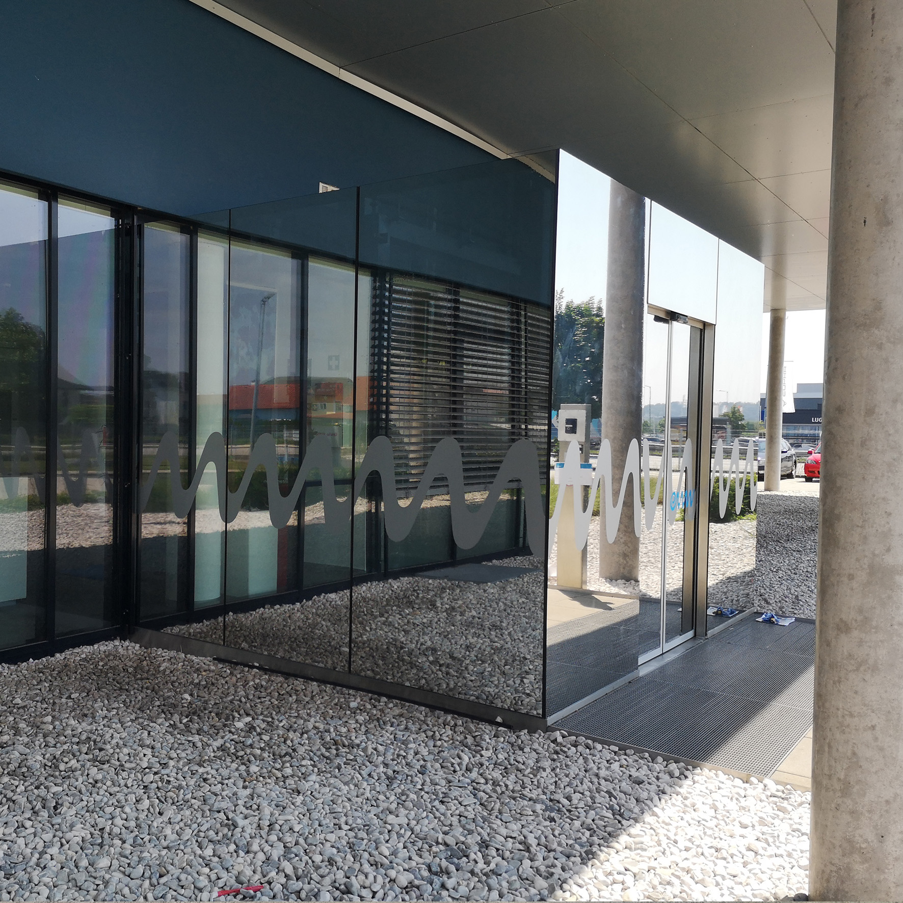 Glasfassade mit Sonnenschutzfolie für UV- und Hitzeschutz kombiniert mit Firmenlogo