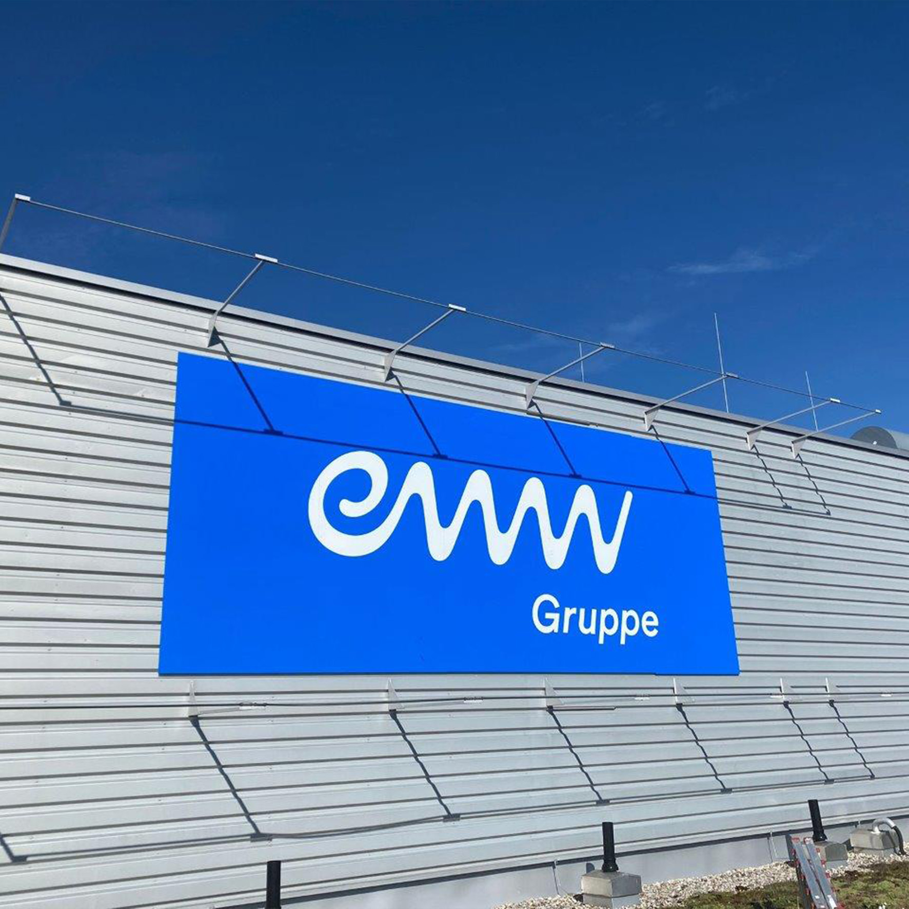 Fassadenschild aus Aluverbund mit Firmenlogo an Außenwand montiert