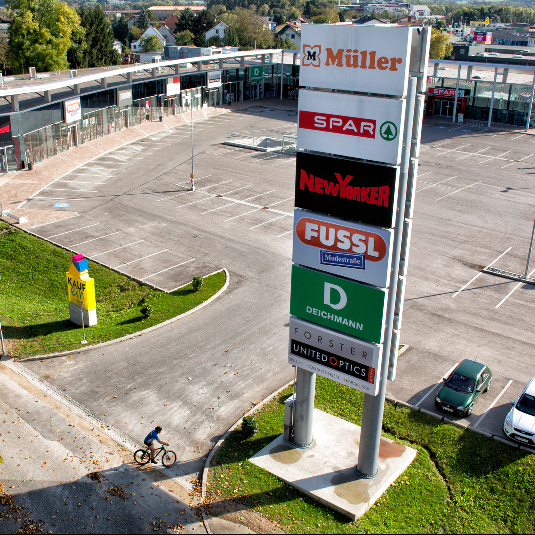 Außenwerbung: Werbeturm mit Acrylfront vor Einkaufszentrum