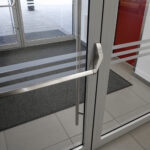 Nahaufnahme einer Anlaufschutzfolie auf Glastür gegen Fingerabdrücke und Stöße